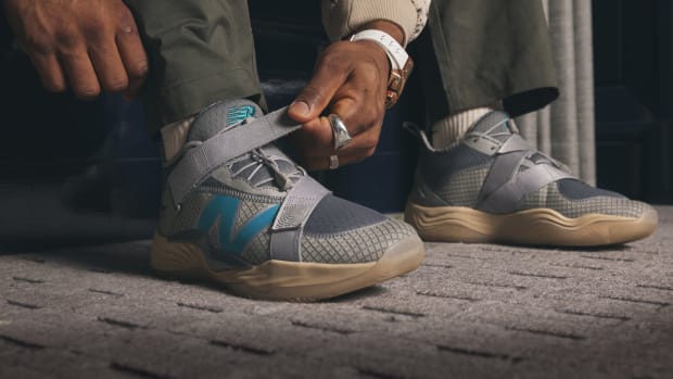 Francisco Lindor ties his grey New Balance shoes.